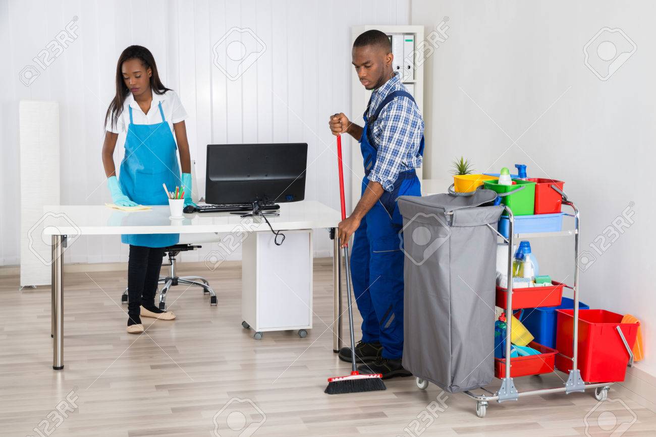 Male And Female Cleaners Cleaning Office
