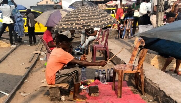 cireur kinshasa 2 696x398 2 - À Kinshasa, des jeunes cirent les chaussures des passants pour subvenir à leurs besoins